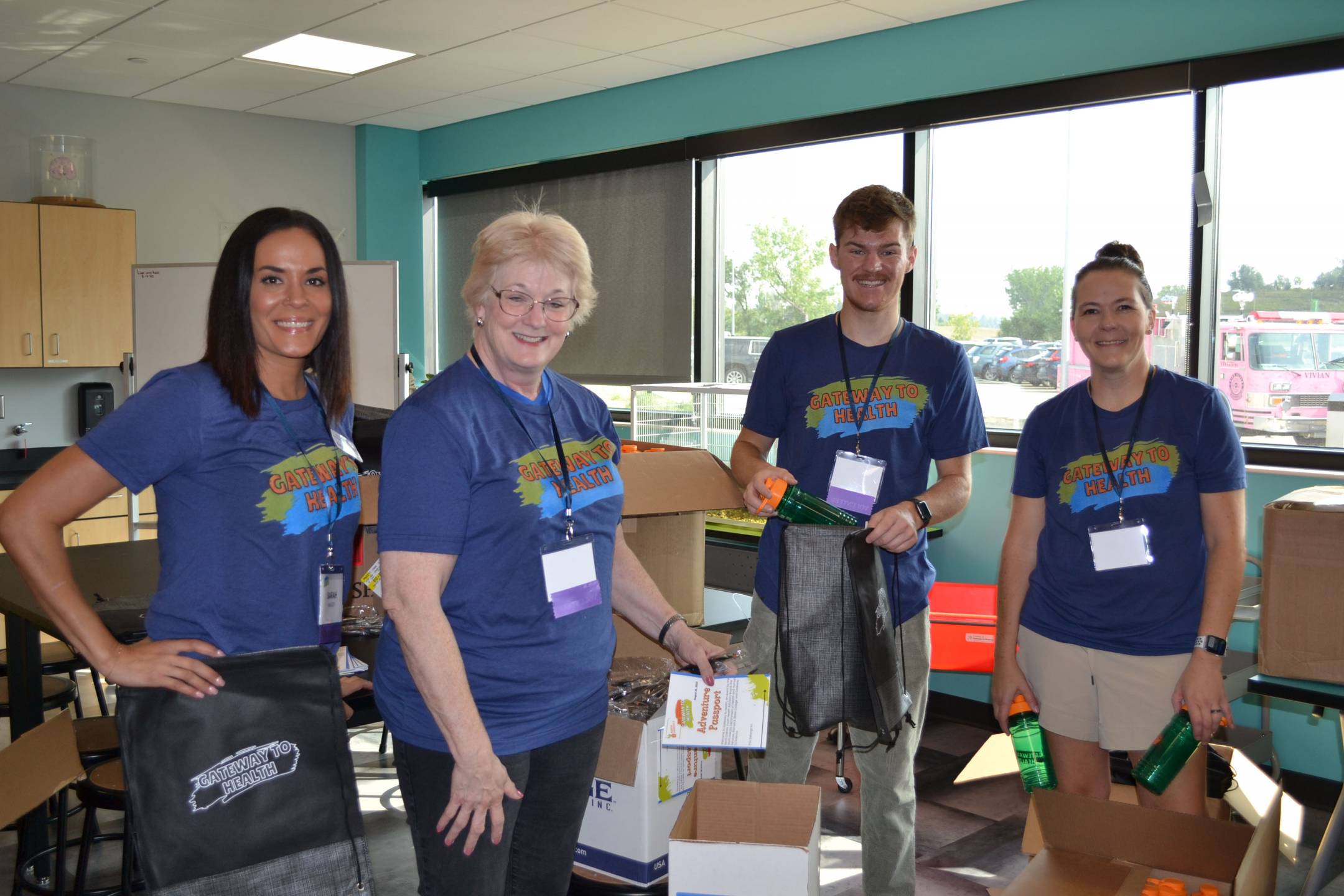 one male and three female volunteers wearing matching blue gateway to health event shirts