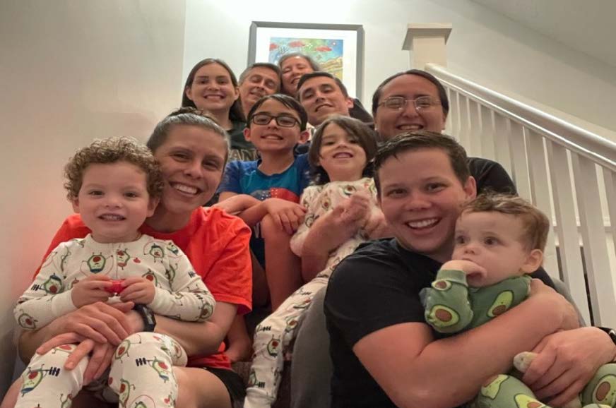 group of young children and adults sitting on a staircase