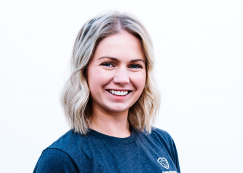 headshot of a woman with short blonde hair and a blue shirt smiling