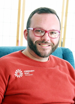 headshot of Cody Severson a white male with a red shirt red glasses and brown short hair with a beard