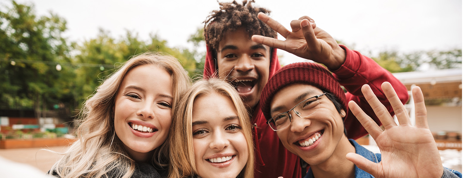 2 female and 2 male teens smiling for a group photo