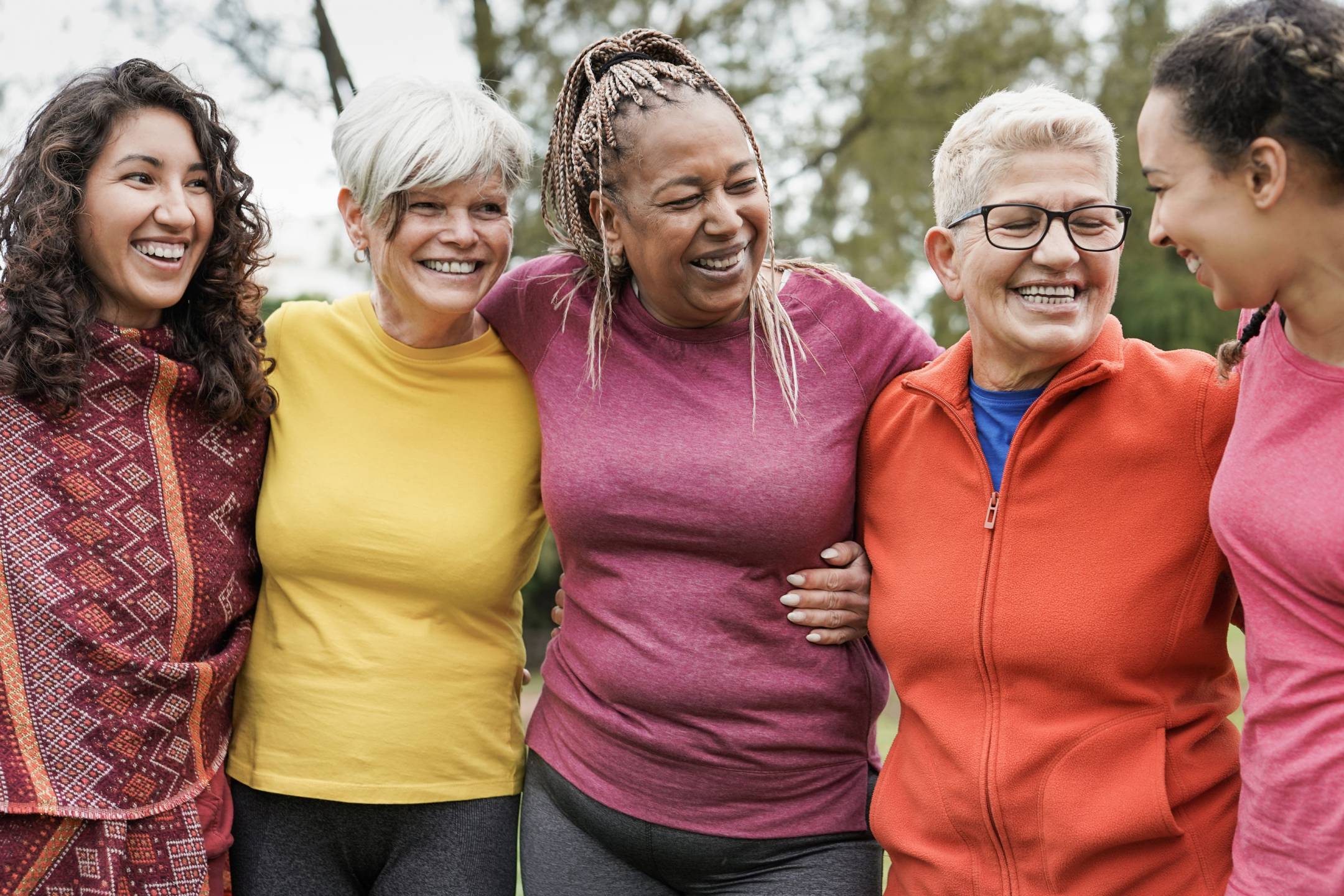 Five smiling women arm in arm 