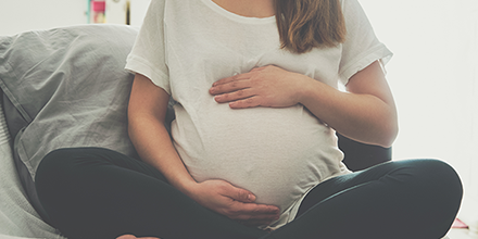 pregnant woman cradling her stomach