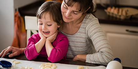 a grandmother bakes cookies with her granddaughter