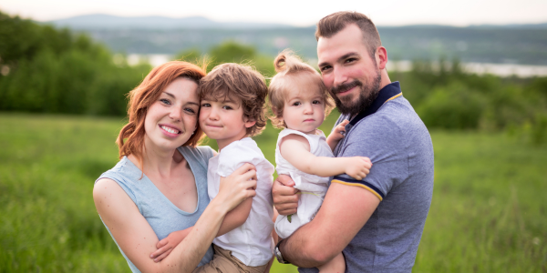 two parents holding young children
