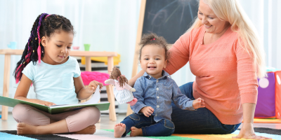 women sitting on floor with two young children