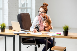 Mother working with an infant in the workplace