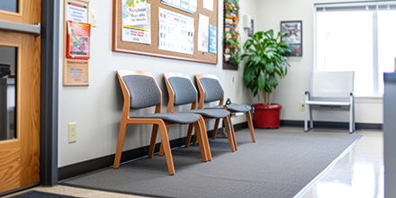 a waiting area with a plan, chairs, and a pinboard.