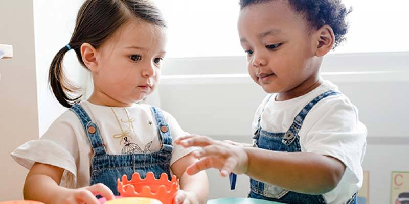 two toddlers playing with toys