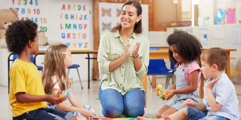 Early Childhood teacher sitting with children