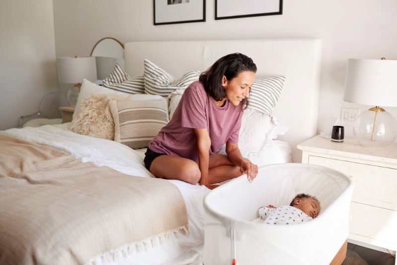 Woman looking at her baby in a crib